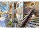 Condo exterior showing private stairway, small landscaped area, and building architectural details on a sunny day at 5052 S Rainbow Blvd # 201, Las Vegas, NV 89118