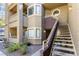 Condo with a private entrance, stairway, and a small landscaped area with shrubbery in front of the building at 5052 S Rainbow Blvd # 201, Las Vegas, NV 89118