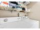 Bright laundry area featuring a white washer and dryer, and metal shelving for storing laundry supplies at 5052 S Rainbow Blvd # 201, Las Vegas, NV 89118