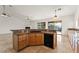 Bright kitchen boasts granite countertops, wood cabinets, black appliances, and opens to the backyard via sliding glass doors at 517 Chance Cove Dr, Henderson, NV 89052