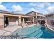 Inviting pool and spa with rock features, covered patio, and solar panels at 517 Chance Cove Dr, Henderson, NV 89052