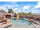 Backyard swimming pool with a rock feature, landscaping, and a clear blue sky at 517 Chance Cove Dr, Henderson, NV 89052