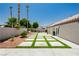 Expansive backyard with modern concrete pavers, artificial turf, and serene landscaping for outdoor enjoyment at 6100 Cocktail Dr, Las Vegas, NV 89130