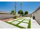 Inviting backyard with artificial turf, stone pavers and beautiful palm trees providing a tranquil outdoor space at 6100 Cocktail Dr, Las Vegas, NV 89130