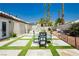Private backyard featuring artificial turf grass, desert landscaping and outdoor seating at 6100 Cocktail Dr, Las Vegas, NV 89130