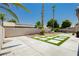 Lush backyard with artificial turf, stone pavers and beautiful palm trees providing a tranquil outdoor space at 6100 Cocktail Dr, Las Vegas, NV 89130