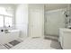 Bright bathroom featuring soaking tub, glass shower, white cabinetry, and decorative floors at 6100 Cocktail Dr, Las Vegas, NV 89130