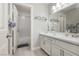 Bright bathroom features white cabinetry, quartz countertops, a shower with herringbone tile, and modern fixtures at 6100 Cocktail Dr, Las Vegas, NV 89130