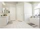 Spacious bathroom featuring dual entry doors, white cabinets, and a soaking tub at 6100 Cocktail Dr, Las Vegas, NV 89130