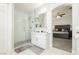 Modern bathroom with a glass-enclosed shower, white cabinets, and access to the primary bedroom at 6100 Cocktail Dr, Las Vegas, NV 89130