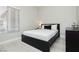 Modern bedroom with a dark-colored bed frame, white linens, and window with horizontal blinds at 6100 Cocktail Dr, Las Vegas, NV 89130