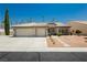 Exterior of a single-story home with three-car garage, desert landscaping, and tile roof at 6100 Cocktail Dr, Las Vegas, NV 89130