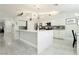 Bright open kitchen with white cabinets, stainless steel appliances and island, with tile flooring throughout at 6100 Cocktail Dr, Las Vegas, NV 89130