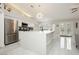 Open concept kitchen with white cabinetry, stainless steel appliances, island with sink and backyard access at 6100 Cocktail Dr, Las Vegas, NV 89130