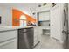 Modern kitchen features stainless steel appliances, white cabinetry, tile floors, and a built-in desk area at 6100 Cocktail Dr, Las Vegas, NV 89130