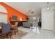 Bright open-concept space with orange accent wall, dining set, and large living area at 6100 Cocktail Dr, Las Vegas, NV 89130
