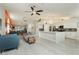 Open-concept living room with tile floors, ceiling fans, and white kitchen with island at 6100 Cocktail Dr, Las Vegas, NV 89130