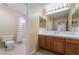 Well-lit bathroom featuring toilet, shower, and vanity with large mirror at 6209 Exquisite Ave, Las Vegas, NV 89110