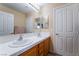 Bright bathroom featuring a double sink vanity with white tile countertops and wood cabinets at 6209 Exquisite Ave, Las Vegas, NV 89110