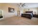 Spacious main bedroom with a large bed, ceiling fan, and carpet flooring at 6209 Exquisite Ave, Las Vegas, NV 89110