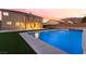 A beautiful backyard pool featuring mountain views and a home exterior at dusk at 6209 Exquisite Ave, Las Vegas, NV 89110