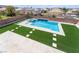 Beautiful in-ground pool and spa with modern water feature and artificial turf surround at 6209 Exquisite Ave, Las Vegas, NV 89110