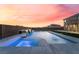 An outdoor swimming pool and spa area with waterfall feature at sunset at 6209 Exquisite Ave, Las Vegas, NV 89110