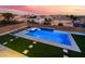 A backyard featuring a pool with a waterfall and spa, surrounded by artificial grass at 6209 Exquisite Ave, Las Vegas, NV 89110