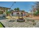 Cozy backyard setup with a stone fire pit, chairs, and a view of the charming home exterior at 671 Riata Way, Las Vegas, NV 89110