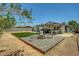 Inviting backyard featuring an artificial grass lawn and a charming paved fire pit area at 671 Riata Way, Las Vegas, NV 89110