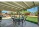 A covered patio with outdoor seating, ideal for relaxing and enjoying the well-manicured backyard at 671 Riata Way, Las Vegas, NV 89110
