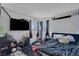 Bedroom with black rug, large TV and two windows with curtains at 671 Riata Way, Las Vegas, NV 89110