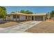 Single-story home with stucco exterior, two-car garage, gravel landscaping and long concrete driveway at 671 Riata Way, Las Vegas, NV 89110