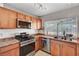 Well-lit kitchen with stainless steel appliances, wood cabinets, and a double sink under the window at 671 Riata Way, Las Vegas, NV 89110