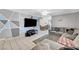 Open living room area featuring tile flooring, grey sofa, dining area and geometric-painted wall at 671 Riata Way, Las Vegas, NV 89110