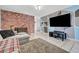 Interior view of the living room with brick fireplace and decorative accent wall at 671 Riata Way, Las Vegas, NV 89110