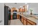 Efficient kitchen featuring black appliances, wood cabinets, and durable countertops at 6868 Sky Pointe Dr # 1107, Las Vegas, NV 89131
