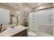 Bright bathroom featuring a dark vanity with a white sink and walk-in shower with sleek glass door at 7224 Piute Mesa St, North Las Vegas, NV 89084
