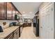 Spacious kitchen featuring granite countertops, dark wood cabinetry, and stainless steel appliances at 7224 Piute Mesa St, North Las Vegas, NV 89084