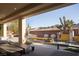 A covered patio with comfortable seating and a view of the landscaped backyard at 80 Glade Hollow Dr, Las Vegas, NV 89135