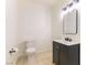 Simple half-bathroom with tile flooring, toilet, and sink with black vanity at 8650 W Verde Way, Las Vegas, NV 89149