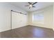 Bedroom features a ceiling fan, wood-look flooring, sliding closet doors, and a window with shutters at 8650 W Verde Way, Las Vegas, NV 89149