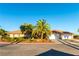 Attractive single-story home featuring mature landscaping, lush lawn, palm trees, and a three-car garage at 8650 W Verde Way, Las Vegas, NV 89149