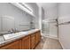 Bathroom featuring dual sinks, granite countertops, wood cabinets and glass enclosed shower at 8805 Jeffreys St # 1048, Las Vegas, NV 89123
