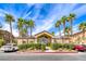 Community clubhouse entrance surrounded by lush landscaping and tropical palm trees at 8805 Jeffreys St # 1048, Las Vegas, NV 89123