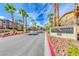 Pebble Creek Village entrance with lush landscaping and swaying palm trees at 8805 Jeffreys St # 1048, Las Vegas, NV 89123