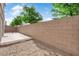 Private backyard featuring a wood deck, gravel landscaping, and a brick privacy wall at 9024 Hazy Haven Ct, Las Vegas, NV 89149