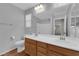 Bright bathroom featuring double sinks, wood cabinets, and wood-look flooring at 9024 Hazy Haven Ct, Las Vegas, NV 89149