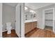 Bright bathroom featuring double sinks, wood cabinets, and wood-look flooring at 9024 Hazy Haven Ct, Las Vegas, NV 89149