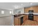 Bright kitchen with stainless steel appliances, wood cabinets and an open layout to the living area at 9024 Hazy Haven Ct, Las Vegas, NV 89149